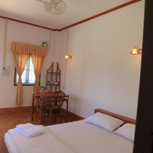 孟丰沙湾孔基欧旅馆的一间卧室设有两张床、一把椅子和一个窗户。