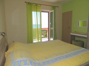 诺瓦利娅德诺娜公寓的一间卧室设有一张床和一个阳台的窗户。