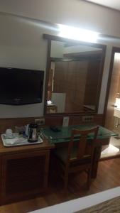 孟买The Royal Orchid Hotel, Chembur的客房设有带镜子和椅子的书桌