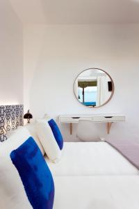 基普塞利加拉蒂亚酒店的一间卧室配有一张白色的床、蓝色枕头和镜子