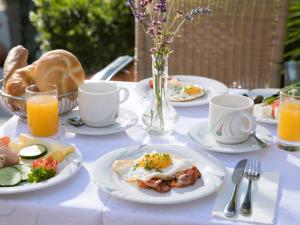 乌特普伦斯塔滕沙晨瓦尔德餐厅酒店的一张带早餐食品和饮料盘的白色桌子