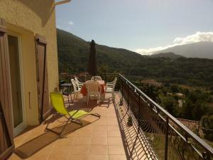 Ucciani95m2 au calme à 25mn AJACCIO, plages, linge inclus parking ok的阳台,配有桌椅