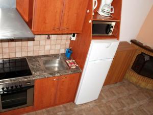 阿亚安娜Agia Anna Apartments的一个带木制橱柜和水槽的小厨房