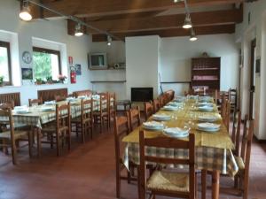 AmandolaRifugio Garulla的大型用餐室配有长桌和椅子