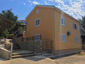卢什蒂卡Žanjice Luxury Suite的一座黄色的小房子,设有楼梯和栅栏