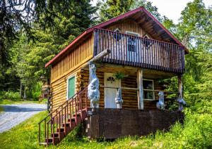 Moose Pass午夜太阳山林小屋的小木屋设有门廊和阳台