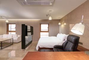 首尔Capace Hotel Gangnam的一间卧室配有一张床、一张沙发和一张桌子