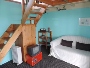 欧尼罗亚怀赫科岛塔瓦山林小屋 - 仅限成人的一间带床和电视的房间以及楼梯