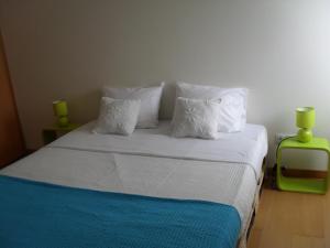 大里贝拉106 Green North的一间卧室配有带白色床单和枕头的床。