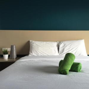 华欣华欣码头公寓的坐在床上的绿色填充动物