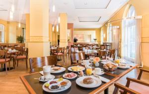 波恩列诺努集团酒店的用餐室配有餐桌和食物