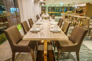 合艾New Season Square Hotel - SHA Plus的餐厅里一张长木桌子和椅子