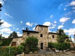 拉达-因基安蒂Belvilla by OYO Villa Ulivo的蓝色天空的古老石屋
