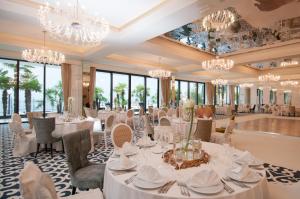 奥帕提亚Amadria Park Hotel Royal的用餐室配有白色桌椅和吊灯。