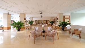 勒吉安财富套房酒店的酒店大堂设有桌椅和植物