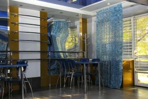 卡缅斯科耶Zolotie Peski的餐厅设有蓝色的椅子和桌子及窗户。