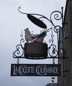 CarantillyLa Cocotte Gourmande的咖啡馆的标志,上面有鸡