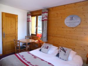 普拉洛尼昂拉瓦努瓦斯Epicéa Lodge Hôtel的一间卧室设有一张床和木墙