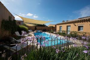 卡布拉斯阿克西尼阿尔伯格迪福索酒店的一座鲜花盛开的庭院内的游泳池