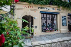 皮尔纳Pirnscher Hof - Hotel Garni的窗户上有鲜花的酒店前方的商店