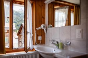 乌尔里兴努费恩酒店的一间带水槽和镜子的浴室以及窗户。