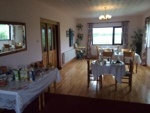 BallylongfordGreenfields Farmhouse的一间设有两张桌子和镜子的用餐室