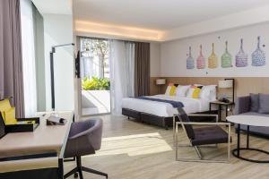 曼谷曼谷名致酒店式服务公寓的配有一张床和一张书桌的酒店客房