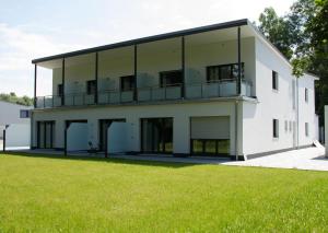 Ebenhausen WerkBoardinghouse-Ebenhausen的一座白色的大建筑,设有绿色草坪