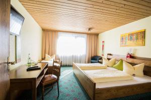 纽伦堡Hotel Avenue Altenfurt的酒店客房配有两张床和一张书桌