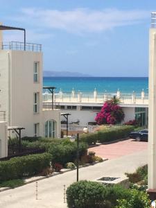 GhaziveranAphrodite Apartments North Cyprus的一座白色的建筑,背靠大海