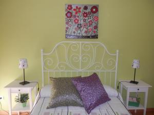 韦斯卡Acogedor Apartamento En Huesca的一间卧室配有白色的床、两张桌子和一幅画