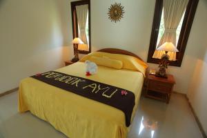 沙努尔旁多克阿玉酒店的一间卧室,卧室里配有一张写着快乐周年纪念的标牌的床