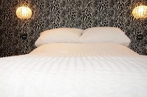 迪斯利Frankies Wine Bar & Lodge的一间卧室配有一张黑色和白色壁纸的床