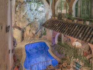 舍夫沙万里亚德彻利法旅馆的植物间的一个蓝色游泳池