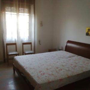 托雷苏达Villa Loredana的一间卧室配有一张带两把椅子的床和一扇窗户