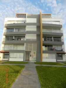 帕拉卡斯Departamento con Vista al Mar- Condominio Nautico Las Velas的前面有人行道的高大的白色建筑