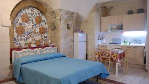 莫迪卡Casa MaFaCò的一间带蓝色床的卧室和一间厨房