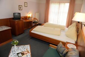 斯皮特安德劳Hotel Edlingerwirt - Sauna & Golfsimulator inklusive的小酒店客房配有一张床和一张书桌