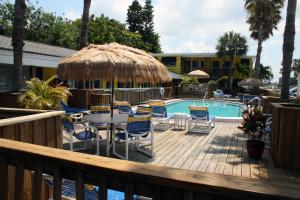 克利尔沃特赤脚湾度假汽车旅馆的一个带桌椅的甲板和一个游泳池