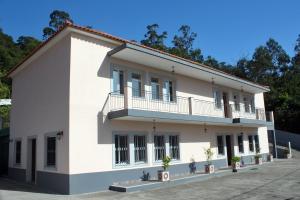 桑塔纳Casa Os Manos的前面有盆栽植物的大白色建筑