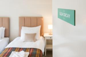 克里安拉利Glenbruar House的酒店客房,设有一张床,墙上有标志