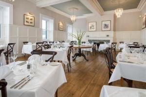 因弗雷里The Inveraray Inn, BW Signature Collection的餐厅设有白色的桌椅和壁炉