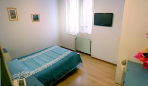 欧斯佩达蒂Albergo Savoia的一间卧室配有一张床和一台电视