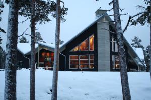 Kvikkjokks KapellÅrrenjarka Mountain Lodge的雪中树林中的房屋