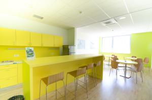 卢布尔雅那Sport Hotel Ljubljana的厨房配有黄色橱柜和桌椅