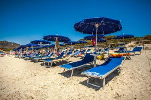 维拉西米乌斯Hotel Fiore Di Maggio的沙滩上的一把椅子和遮阳伞