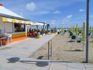 利多迪耶索罗Daina Residence的沙滩上设有餐厅和椅子