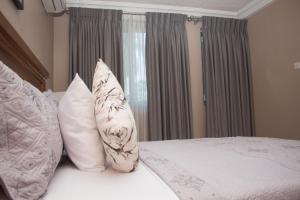 阿克拉Manjaro Suites的一间卧室配有带白色枕头的床