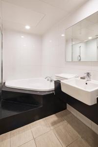 首尔首尔G地酒店的带浴缸、水槽和镜子的浴室