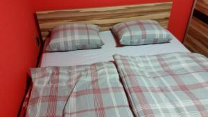 ResnikApartment Borovnica Rogla的配有2个枕头和红色墙壁的单人床